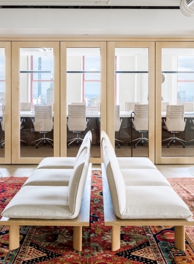 Two rows of three white chairs face away from each other. A well lit conference room is shown in the background.